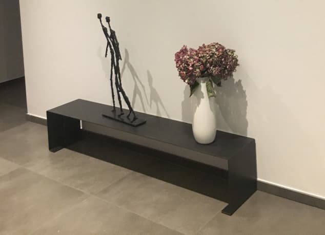 Banc Console basse design en métal accueillant une sculpture en bronze et un vase de fleurs séchées 
