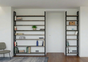 Étagères en bois massif avec cadre métallique noir encadrant une porte blanche, livres et objets décoratifs sur les rayons dans un salon.