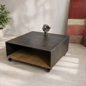 Table basse en métal patine anthracite et chêne sur roulettes, avec un petit projecteur vintage sur le plateau.