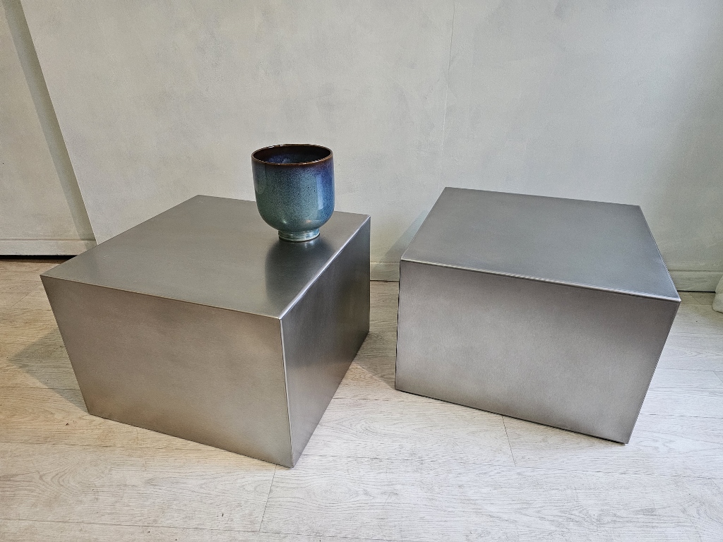 Deux tables basses cubiques en inox brossé sur mesure avec un vase bleu posé sur l'une d'elles.