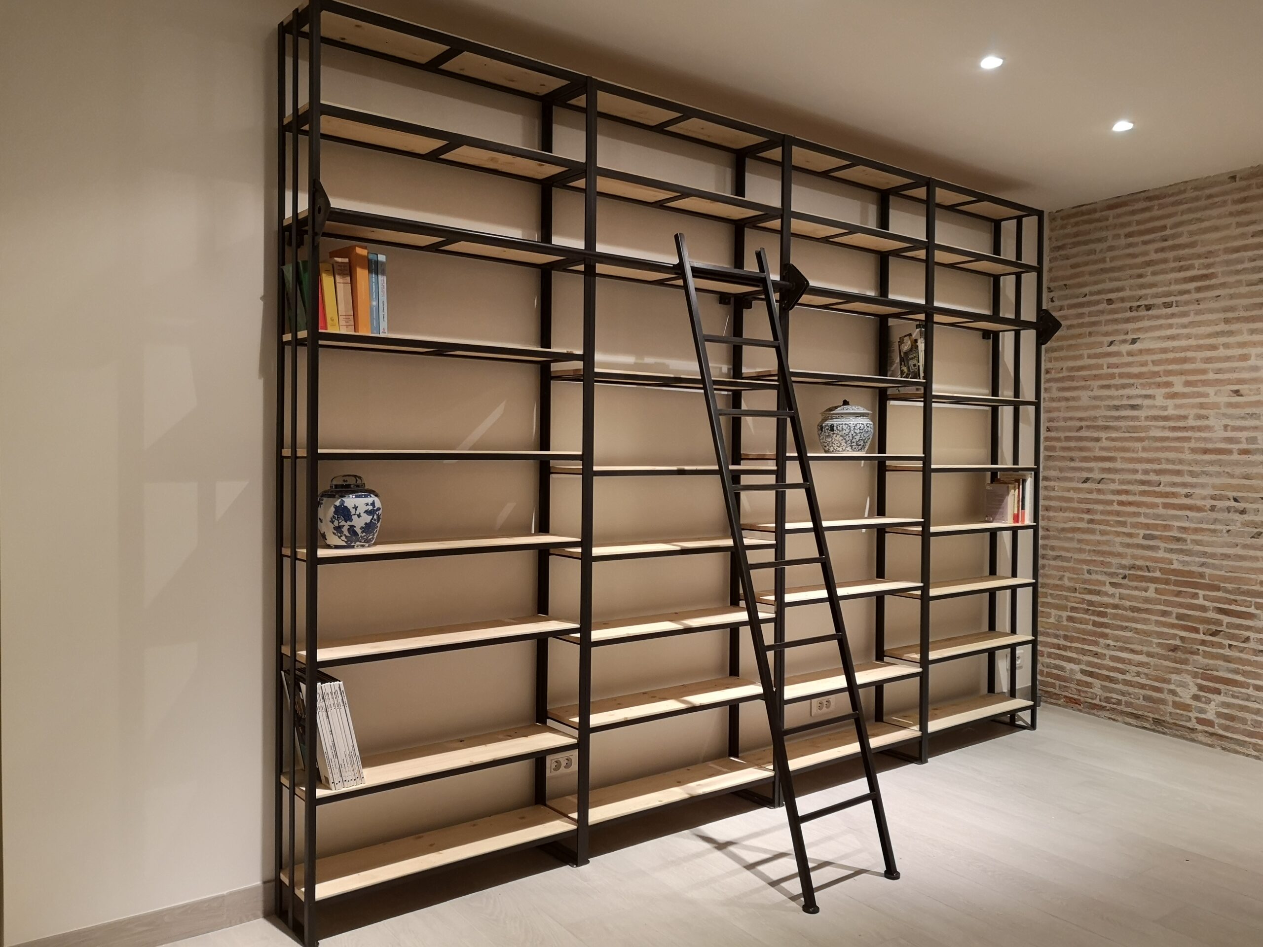 grande bibliothèque murale style industrielle en métal noir et bois clair avec échelle